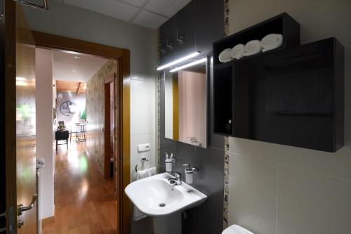ein Badezimmer mit Waschbecken und Spiegel in der Unterkunft Arbesa Huesca in Huesca