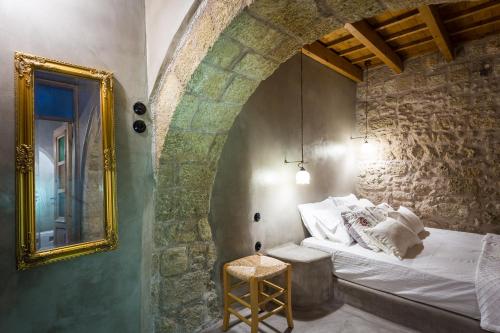 a bedroom with a bed with a mirror and a stool at Rodi in Rhodes Town
