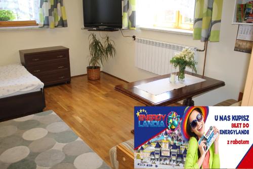 a living room with a table and a book at Apartament Kapi in Kalwaria Zebrzydowska