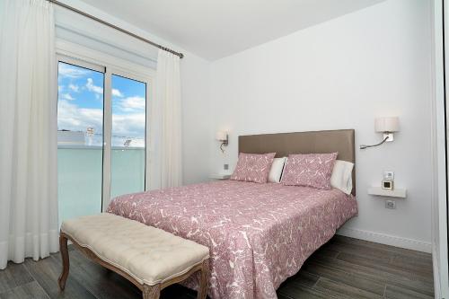 プエルト・デル・カルメンにあるRociega Bの白いベッドルーム(ベッド1台、窓付)