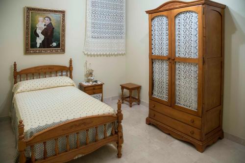 a bedroom with a wooden bed and a wooden cabinet at Apartamento en Edificio Tortosa in Monóvar