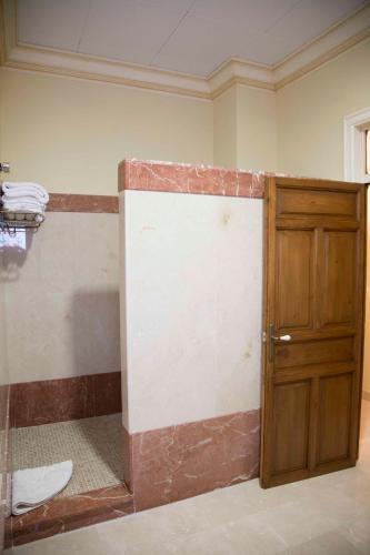 a bathroom with a shower with a wooden door at Apartamento en Edificio Tortosa in Monóvar