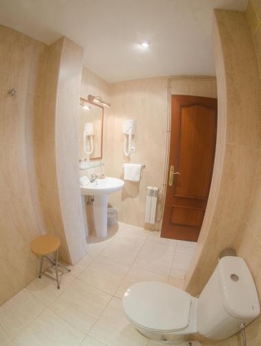 a bathroom with a toilet and a sink at Hotel Costa de Ajo in Ajo