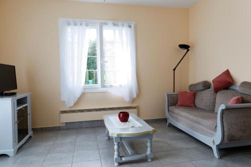 sala de estar con sofá y ventana en Villa Les Bruyères, en Saint-Joseph-de-Rivière