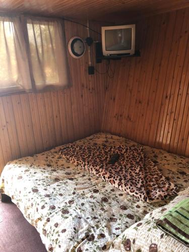 a bedroom with a bed with a leopard print blanket at Camping Robinson Country Club Oradea in Oradea