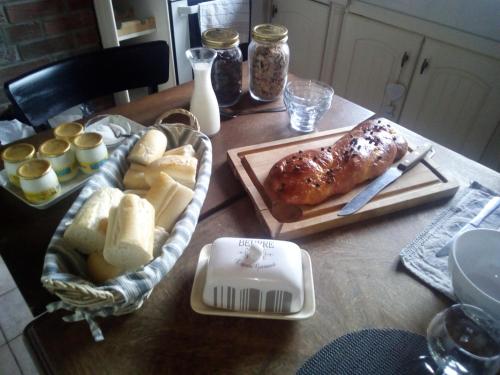 una mesa con pan y comida encima en La Hulotte au Col Haut, en Audrehem