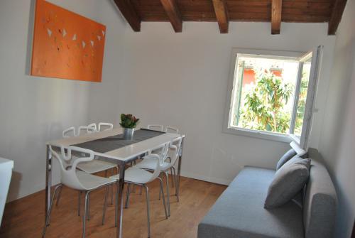 een eetkamer met een tafel en stoelen en een raam bij Casa Fiorella in Caorle