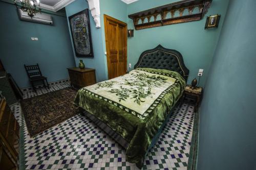 a bedroom with a bed with a green bedspread at Riad Scalia Traditional Guesthouse Fes Morocco in Fès