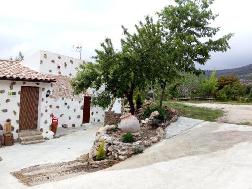 a house with a tree and a building at CASA RURAL "LOS CASARES" in Nerpio