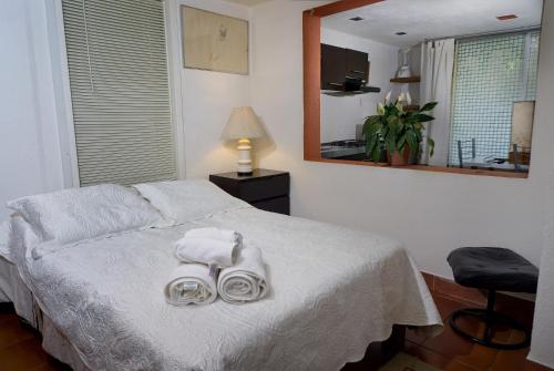 um quarto com uma cama com toalhas e um espelho em Suite 4A, Terraza, Garden House, Welcome to San Angel em Cidade do México