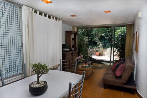 a living room with a table and a couch at Suite 4A, Terraza, Garden House, Welcome to San Angel in Mexico City