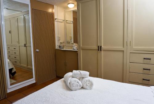 a bedroom with towels on a bed with a mirror at Suite 4A, Terraza, Garden House, Welcome to San Angel in Mexico City