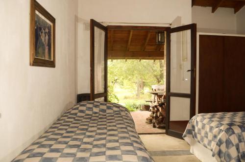 a bedroom with two beds and an open door at Rancho La Peregrina in Nono