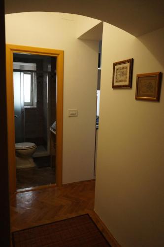 a bathroom with a toilet and a hallway with a doorway at Apartments SAB in Ogulin