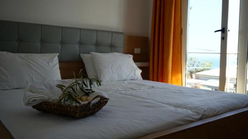 Una cama con una cesta con una ventana en Hotel Ionian, en Dhërmi
