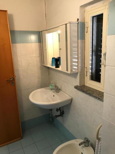 een badkamer met een wastafel en een toilet bij Mansarda pennisi in Le Castella