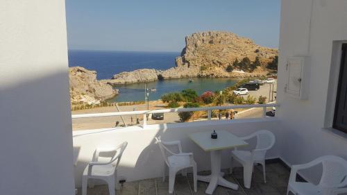 a balcony with a table and a view of the ocean at St. Paul's Bay View Suites in Líndos