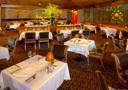 een eetkamer met witte tafels en stoelen bij Cypress Bayou Casino Hotel in Franklin