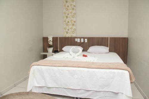 Hotel Acai في Itaituba: غرفة نوم عليها سرير وبجعتين