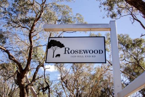 a sign for rosewood sign in front of trees at Rosewood Cottage Mudgee in Grattai