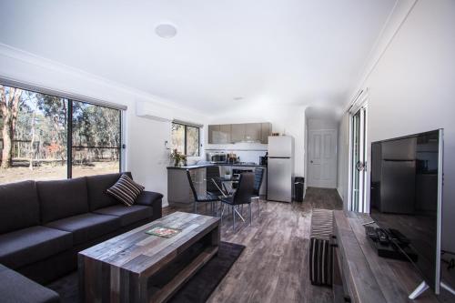 a living room with a couch and a table at Rosewood Cottage Mudgee in Grattai