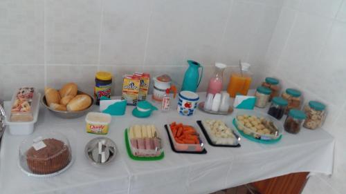 uma mesa com alimentos e outros alimentos sobre ela em Pousada Recanto Dom Lázaro em Cesário Lange