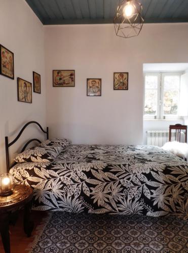 a bedroom with a bed with a black and white comforter at Ponto de Vista - Coimbra in Coimbra