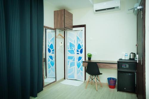 a room with a desk and a glass door at DJ Citi Point Hotel in Kuala Terengganu