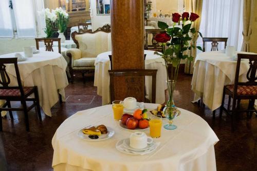 a table with a plate of fruit and drinks on it at Hotel San Giorgio in Venice