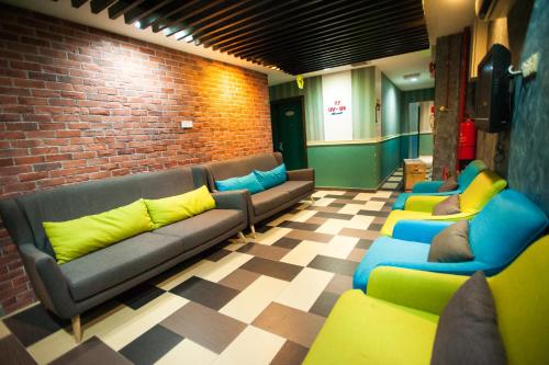 a waiting room with couches and a brick wall at DJ Citi Point Hotel in Kuala Terengganu