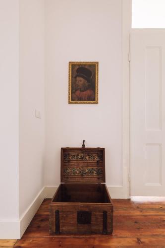 a wooden chest in a room with a picture on the wall at The Visionaire Apartments in Lisbon