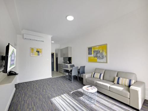 a living room with a couch and a table at Value Suites Penrith in Penrith