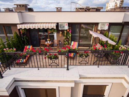 a balcony with chairs and flowers on a building at Sky Garden Apartment Burgas in Burgas