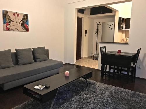 un soggiorno con divano e tavolo di Conta Apartment a Bucarest