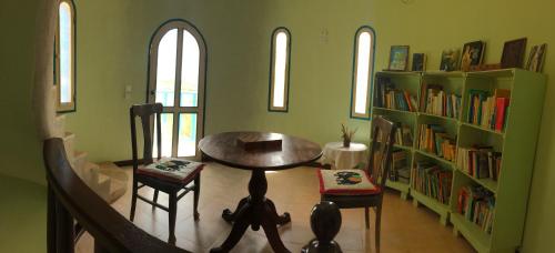 Zimmer mit einem Tisch, Stühlen und Bücherregalen in der Unterkunft Torre Sabina in Vila do Maio