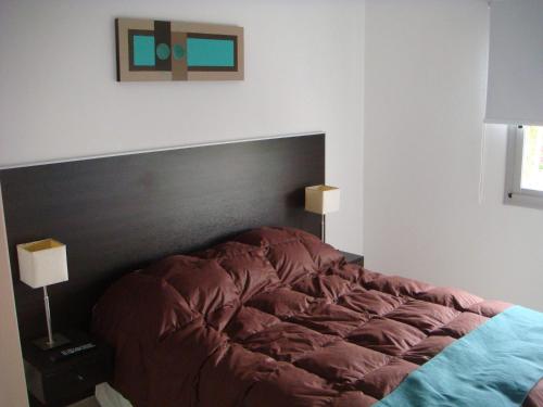 a bedroom with a large bed with a black headboard at Pinamar Alquilo Departamentos Frente Al Mar in Ostende