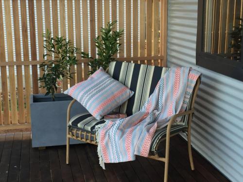 a chair with blankets and pillows on a porch at Manna Hill Farm in West Kentish