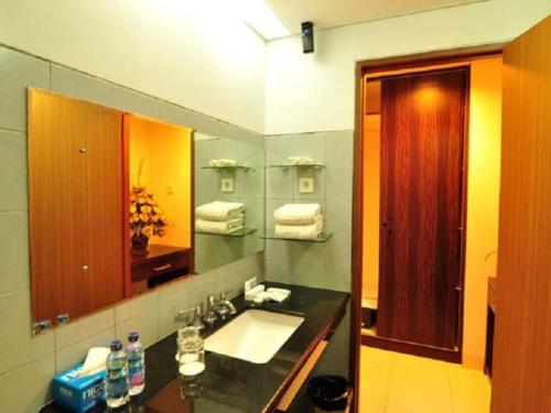 a bathroom with a sink and a mirror at ASTON Ketapang City Hotel in Ketapang