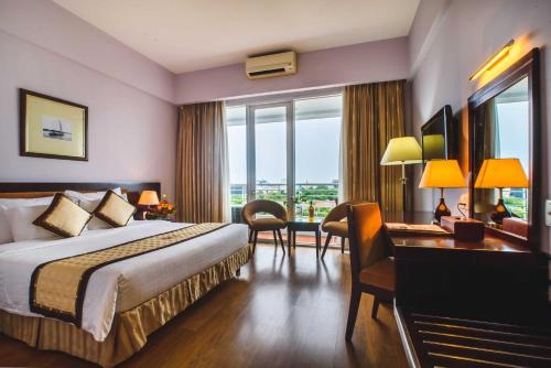 a hotel room with a bed and a desk at Mondial Hotel Hue in Hue