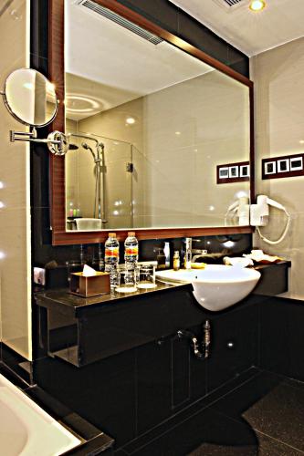 a bathroom with a sink and a large mirror at Best Western Plus Makassar Beach in Makassar