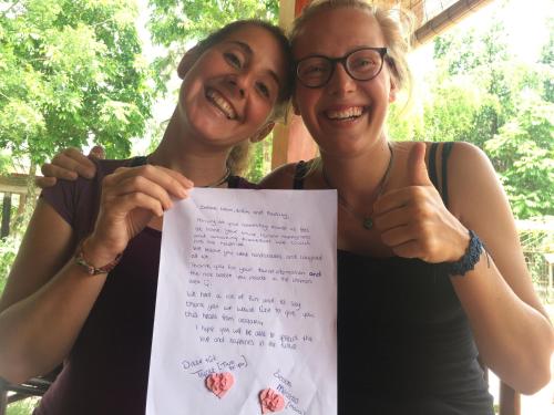 two women are holding up a piece of paper at Tam Coc Friendly Homestay in Ninh Binh