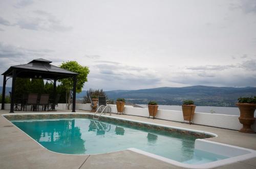a swimming pool with a gazebo on a house at Bella Luna Bed and Breakfast in West Kelowna