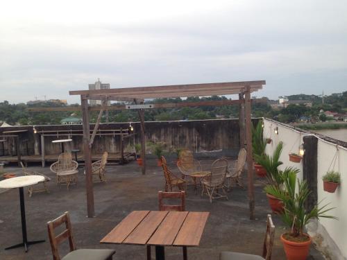 a patio with tables and chairs and a pergola at Woodpecker Lodge, Kuching in Kuching