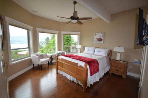 a bedroom with a large bed and windows at Bella Luna Bed and Breakfast in West Kelowna