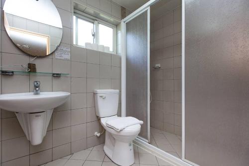 a bathroom with a toilet and a sink and a mirror at Locasu in Datong