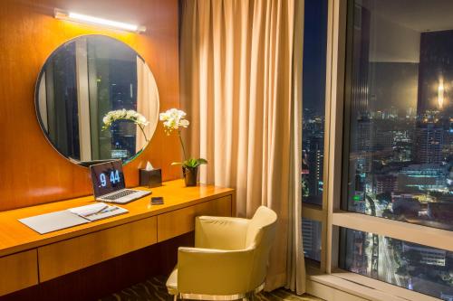 a hotel room with a desk and a window at Premiera Hotel Kuala Lumpur in Kuala Lumpur