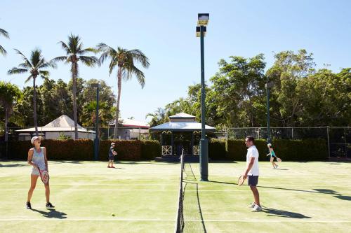 
two women playing tennis on a sunny day at Cable Beach Club Resort & Spa in Broome
