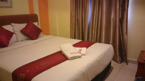 a hotel room with a bed with a towel on it at Sun Inns Hotel Equine, Seri Kembangan in Seri Kembangan
