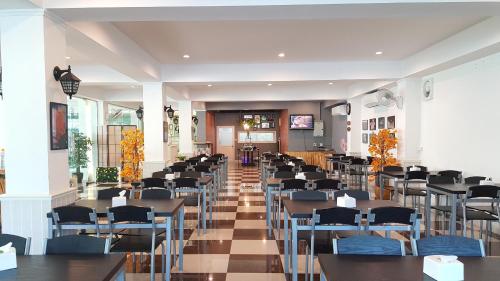 a restaurant with tables and chairs in a room at Gallery Lake View Hotel in Khon Kaen