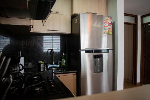 a kitchen with a stainless steel refrigerator with magnets at Apartamento Amoblado En Guadalajara De Buga in Buga